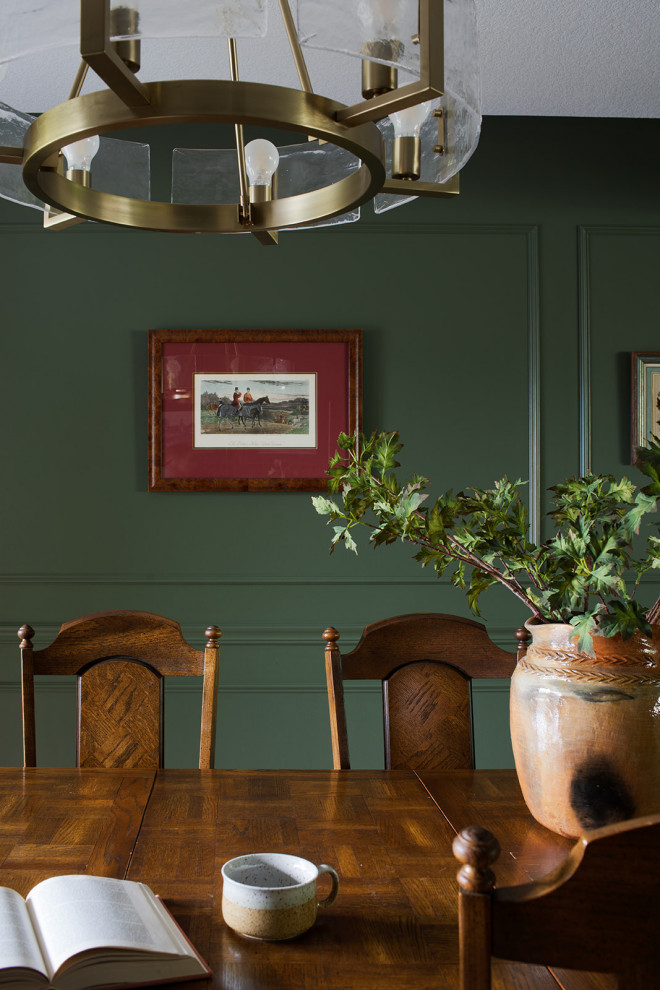 Example of a mid-sized transitional medium tone wood floor, brown floor and wall paneling enclosed dining room design with green walls