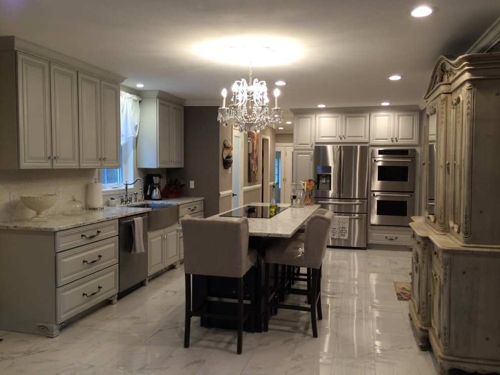 Large traditional u-shaped eat-in kitchen in New York with a farmhouse sink, raised-panel cabinets, white cabinets, granite benchtops, stainless steel appliances, marble floors and with island.