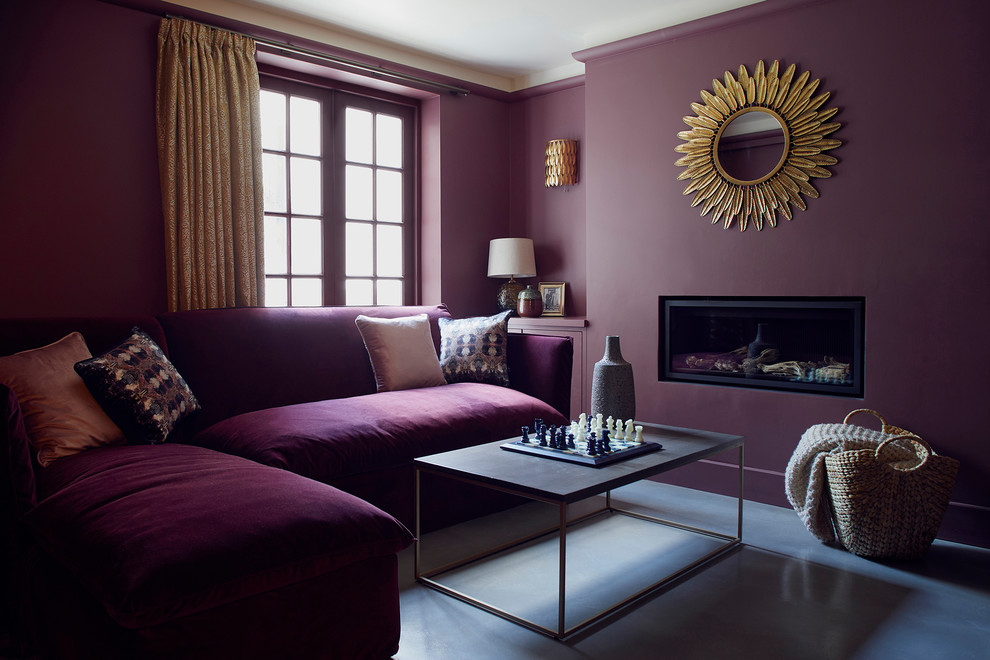 Mid-sized eclectic living room in London with purple walls, concrete floors, a wall-mounted tv and grey floor.
