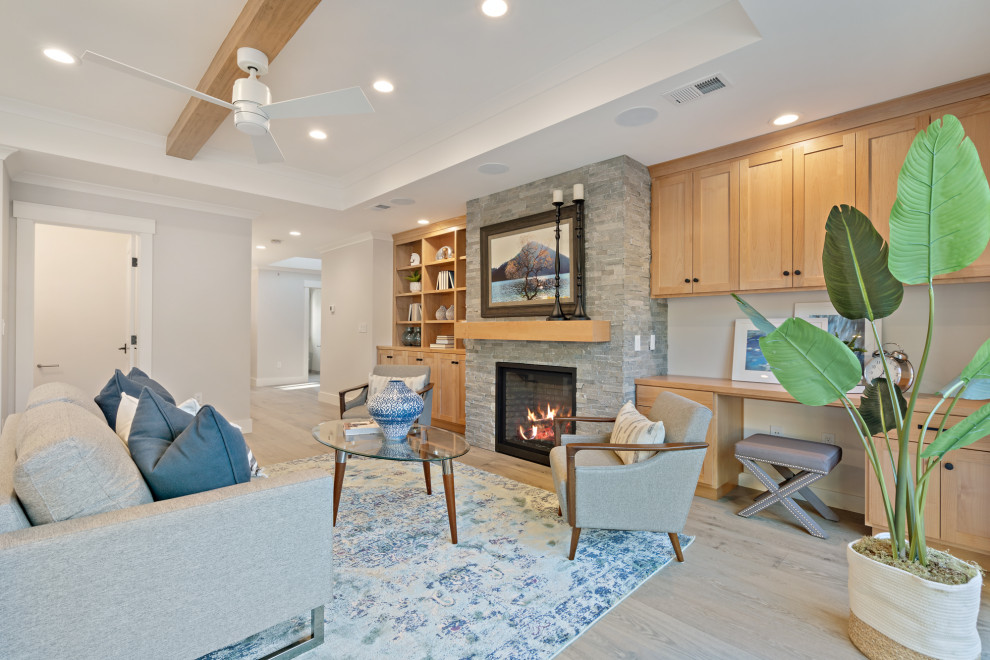This is an example of a mid-sized arts and crafts open concept family room in San Francisco with a home bar, grey walls, medium hardwood floors, a standard fireplace, a stone fireplace surround, a wall-mounted tv and grey floor.