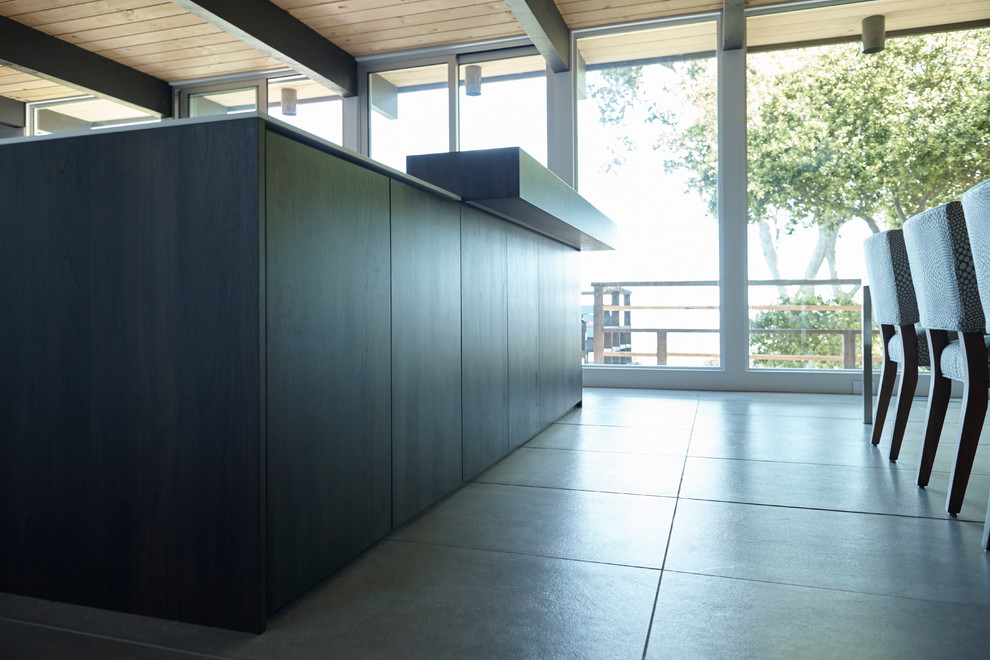 Inspiration for a mid-sized midcentury open plan kitchen in San Francisco with flat-panel cabinets, dark wood cabinets, solid surface benchtops, ceramic floors and multiple islands.