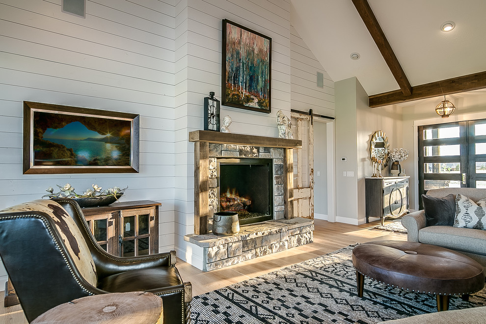 This is an example of a large country formal open concept living room in Other with grey walls, light hardwood floors, a standard fireplace, a stone fireplace surround, no tv and beige floor.