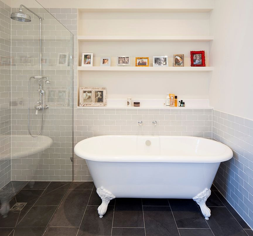 Inspiration for a mid-sized traditional kids bathroom in London with a claw-foot tub, an open shower, gray tile, ceramic tile, white walls, porcelain floors, black floor, an open shower, a console sink, a double vanity and a one-piece toilet.