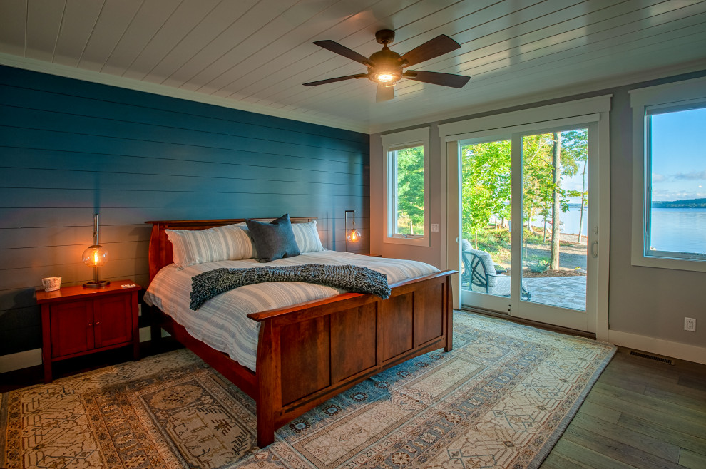 Ejemplo de dormitorio principal de estilo americano extra grande sin chimenea con paredes azules, suelo de madera en tonos medios, suelo marrón, machihembrado y machihembrado