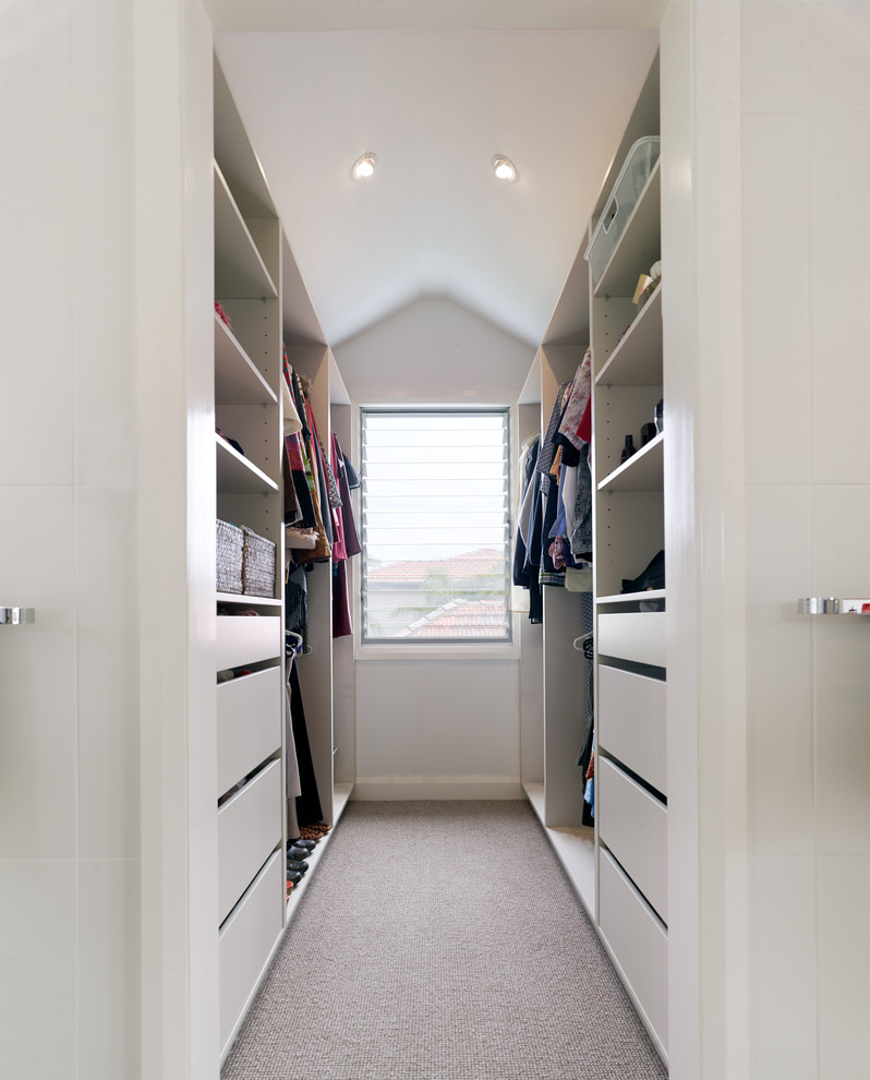 Inspiration for a mid-sized contemporary gender-neutral walk-in wardrobe in Sydney with flat-panel cabinets, white cabinets and carpet.