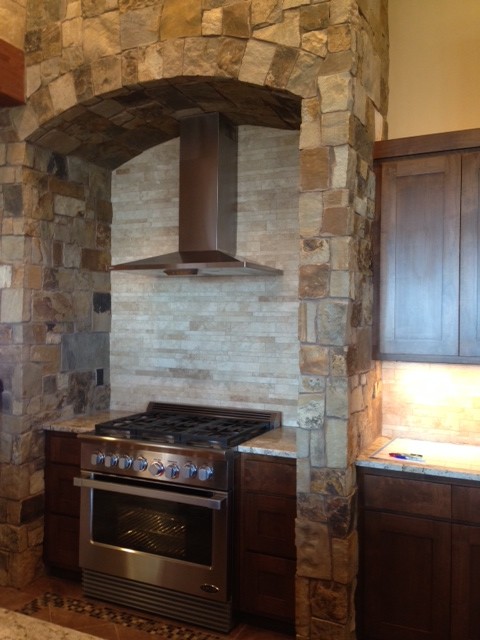Mountain style medium tone wood floor kitchen photo in Seattle with shaker cabinets, granite countertops and an island