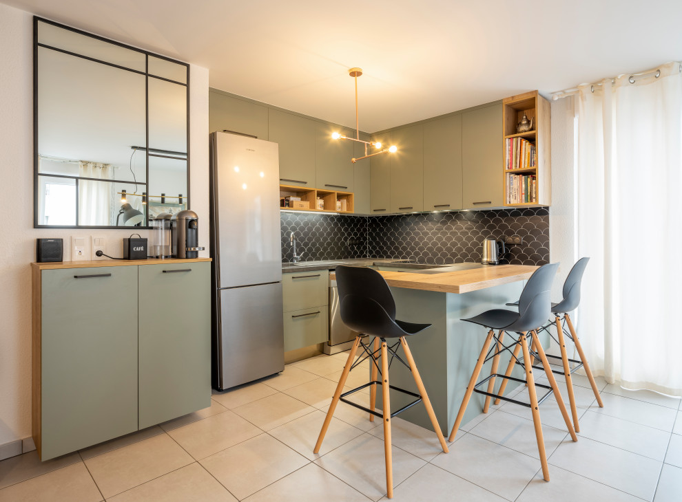 Design ideas for a mid-sized modern u-shaped eat-in kitchen in Strasbourg with an undermount sink, green cabinets, laminate benchtops, black splashback, porcelain splashback, stainless steel appliances, porcelain floors, with island, grey floor and black benchtop.