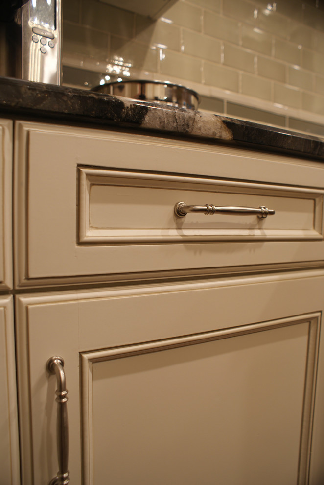 Transitional medium tone wood floor kitchen photo in Dallas with an undermount sink, flat-panel cabinets, white cabinets, granite countertops, beige backsplash, ceramic backsplash, stainless steel appliances, beige walls and an island