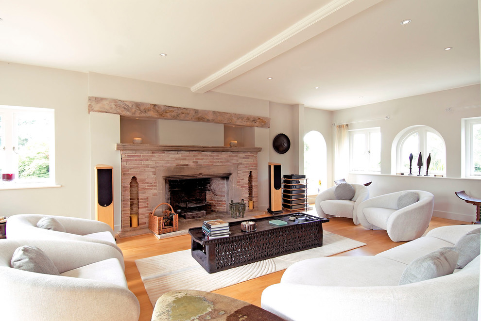Inspiration for a contemporary living room in Surrey with white walls, medium hardwood floors and a standard fireplace.