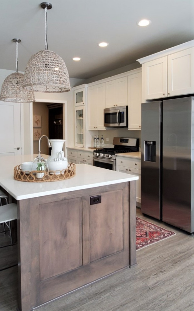 Inspiration for a mid-sized transitional galley vinyl floor and brown floor eat-in kitchen remodel in Chicago with a farmhouse sink, shaker cabinets, white cabinets, quartz countertops, stainless steel appliances, an island and white countertops