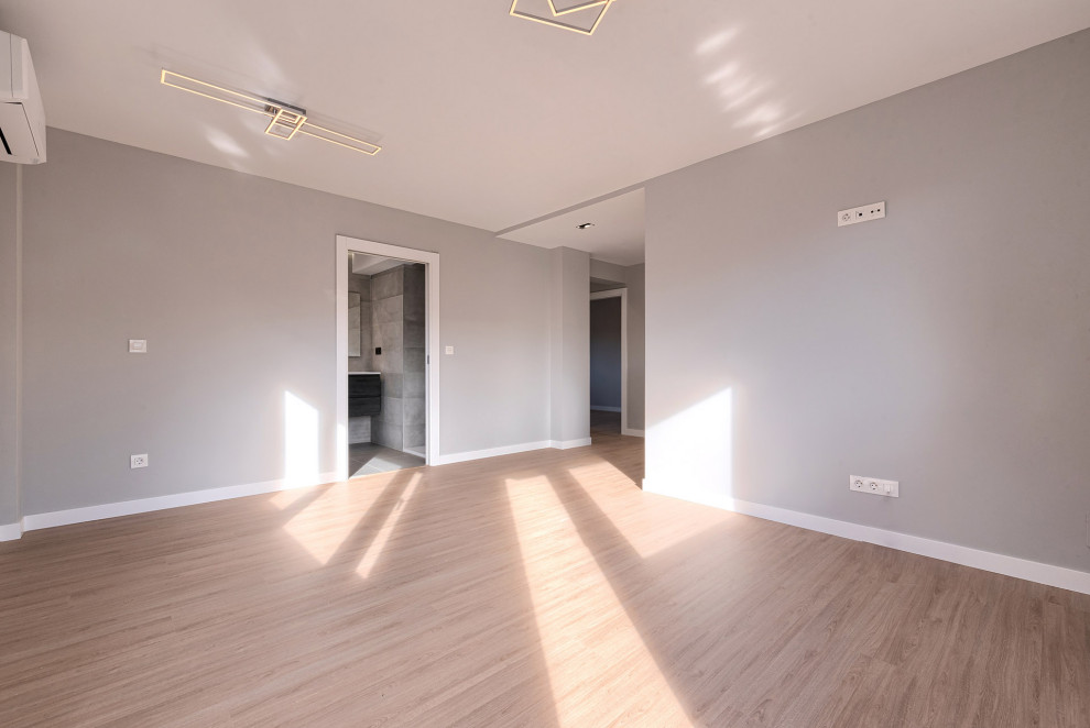 Imagen de sala de estar abierta minimalista de tamaño medio con suelo laminado