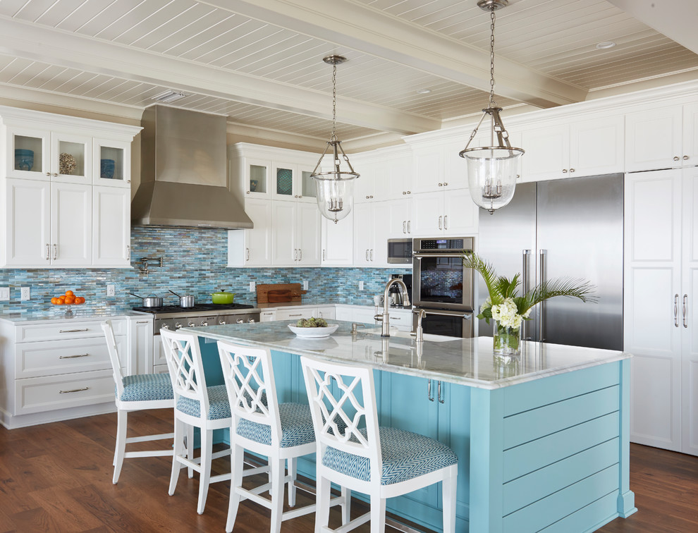 Inspiration for a large beach style l-shaped open plan kitchen in Jacksonville with a farmhouse sink, recessed-panel cabinets, turquoise cabinets, quartzite benchtops, blue splashback, glass tile splashback, stainless steel appliances, medium hardwood floors, with island and brown floor.