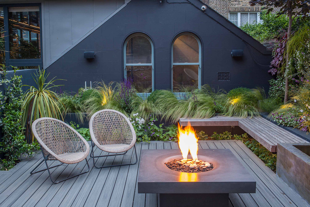 Design ideas for a large contemporary backyard garden in Surrey with decking and a fire feature.
