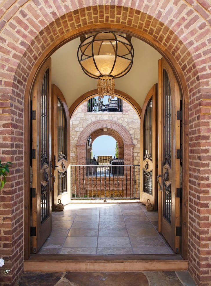 Inspiration for a traditional vestibule in Los Angeles with a double front door and a medium wood front door.