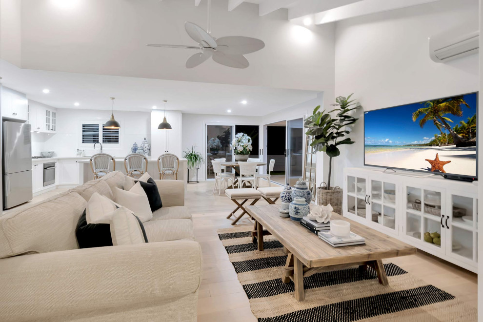 This is an example of a mid-sized beach style open concept home theatre in Gold Coast - Tweed with white walls and laminate floors.