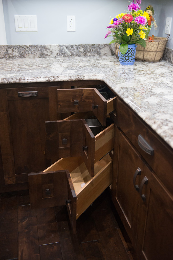Inspiration for a transitional l-shaped open concept kitchen remodel with an undermount sink, shaker cabinets, dark wood cabinets, granite countertops, stainless steel appliances, an island and multicolored countertops