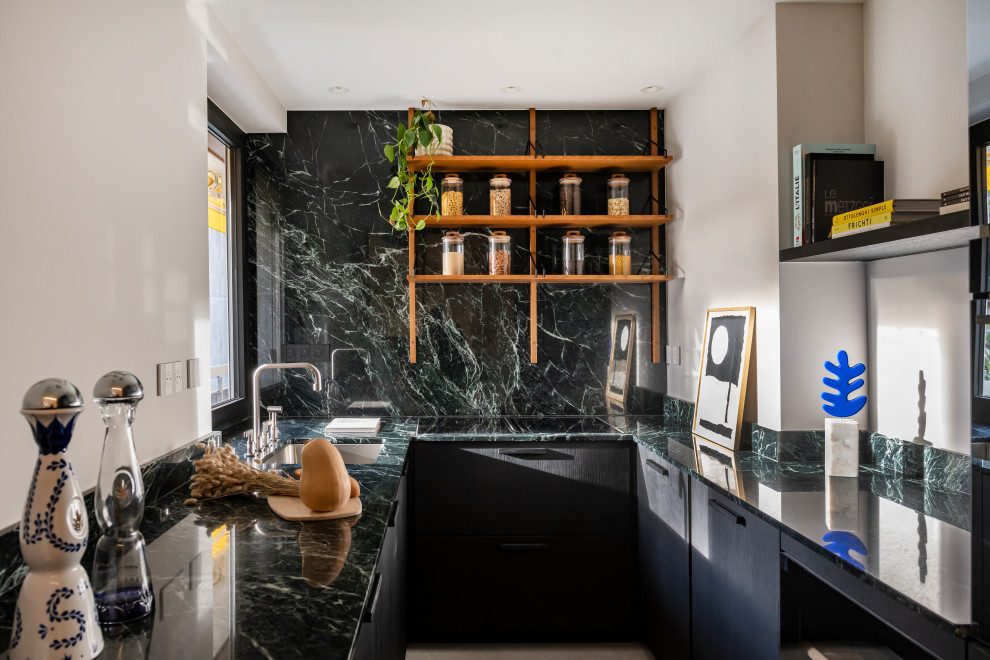 This is an example of a contemporary u-shaped kitchen in Other with a submerged sink, flat-panel cabinets, black cabinets, green splashback, stone slab splashback and green worktops.
