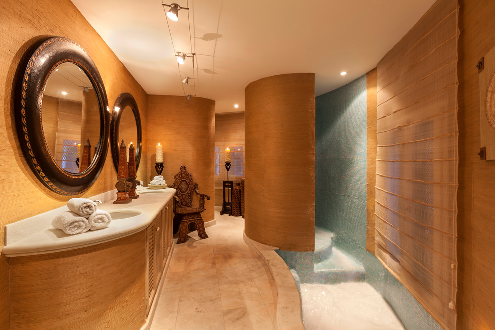 This is an example of a mid-sized tropical bathroom in Other with medium wood cabinets, brown walls, marble floors, a drop-in sink, limestone benchtops and recessed-panel cabinets.