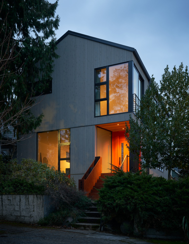 This is an example of a mid-sized scandinavian three-storey grey house exterior in Seattle with wood siding, a gable roof and a metal roof.
