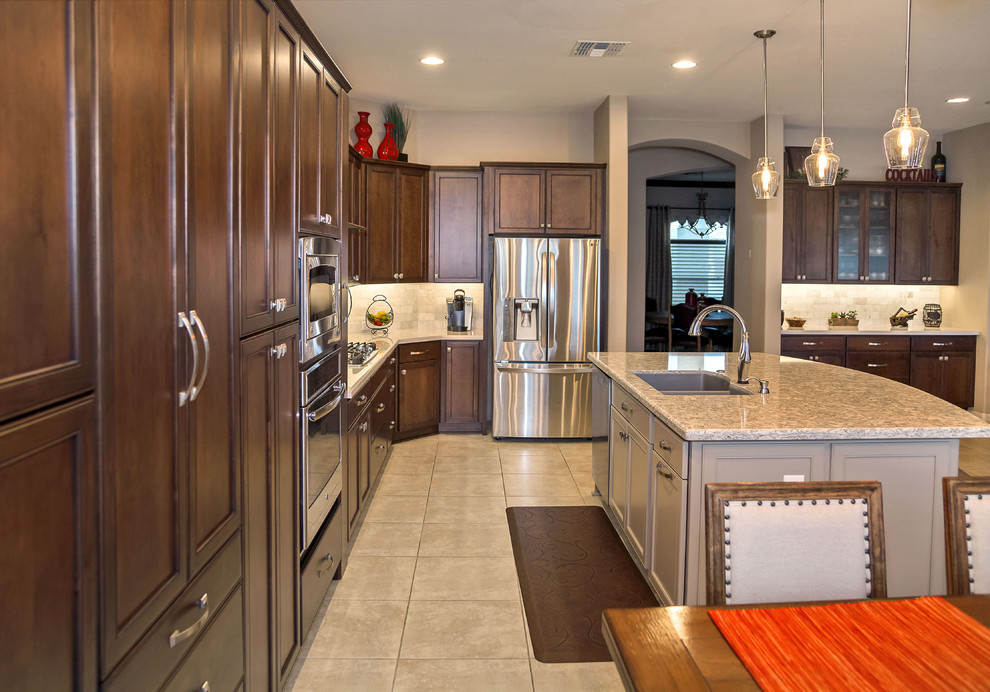 Eat-in kitchen - transitional ceramic tile eat-in kitchen idea in Phoenix with an undermount sink, recessed-panel cabinets, dark wood cabinets, quartzite countertops, gray backsplash, stone tile backsplash, stainless steel appliances and an island