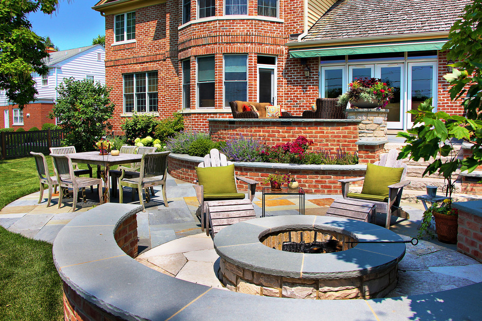 Inspiration for a traditional backyard patio in Chicago with natural stone pavers and a fire feature.