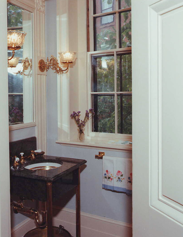 This is an example of a small traditional powder room in Boston with open cabinets, dark wood cabinets, blue walls, an undermount sink and marble benchtops.