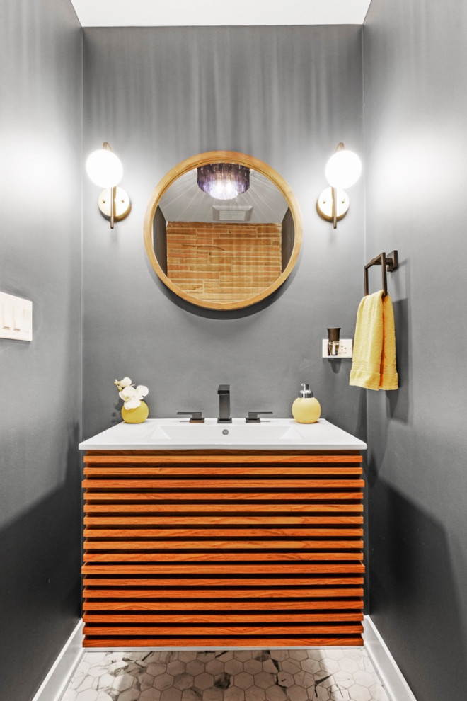 Design ideas for a small midcentury powder room in Chicago with louvered cabinets, medium wood cabinets, a one-piece toilet, blue tile, blue walls, mosaic tile floors, an integrated sink, solid surface benchtops, multi-coloured floor, white benchtops and a floating vanity.