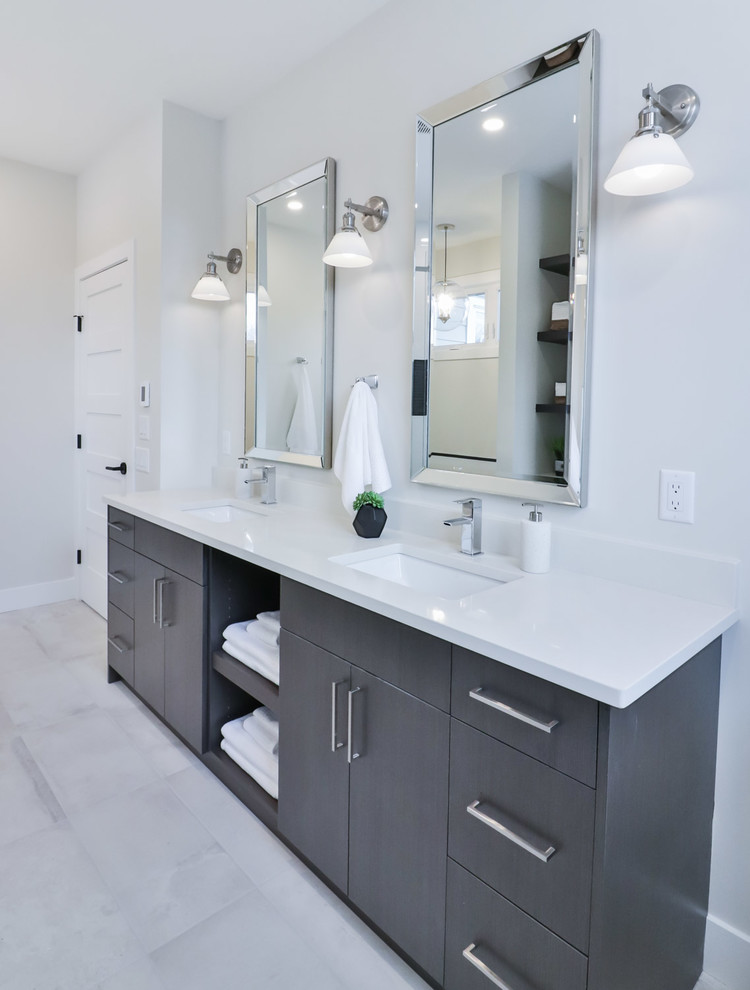Large transitional master white tile and porcelain tile porcelain tile and gray floor drop-in bathtub photo with flat-panel cabinets, gray cabinets, a one-piece toilet, gray walls, an undermount sink and quartz countertops