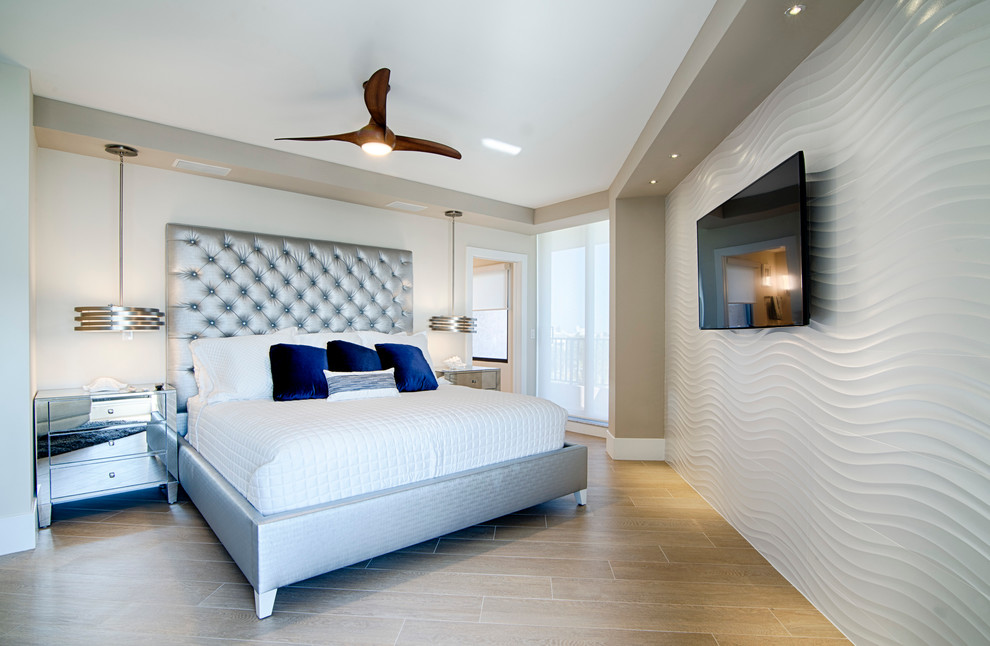 Photo of a mid-sized contemporary master bedroom in Miami with white walls, light hardwood floors, beige floor and no fireplace.