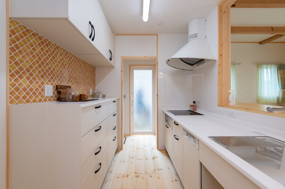 Scandinavian single-wall kitchen in Other with a single-bowl sink, recessed-panel cabinets, white cabinets, light hardwood floors, a peninsula and beige floor.