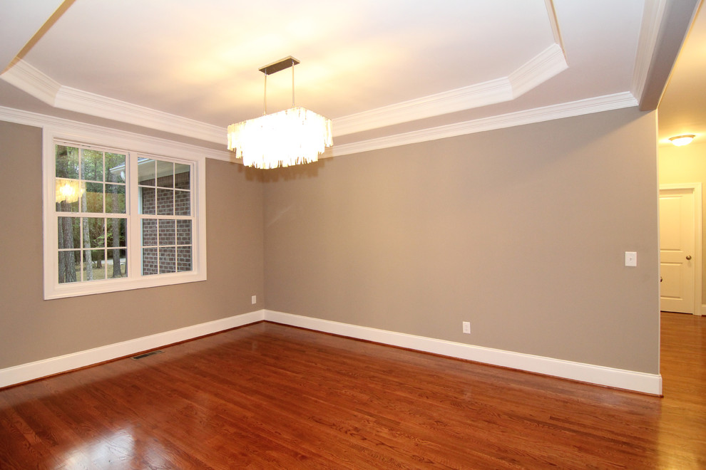 Photo of a mid-sized transitional open plan dining in Raleigh with grey walls and light hardwood floors.