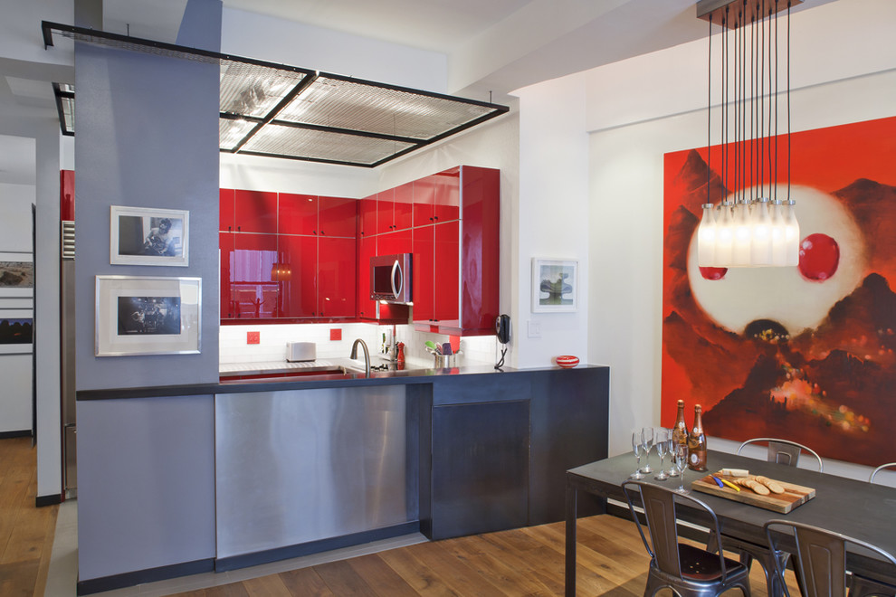 Design ideas for a contemporary eat-in kitchen in New York with stainless steel appliances, flat-panel cabinets, red cabinets and multi-coloured splashback.