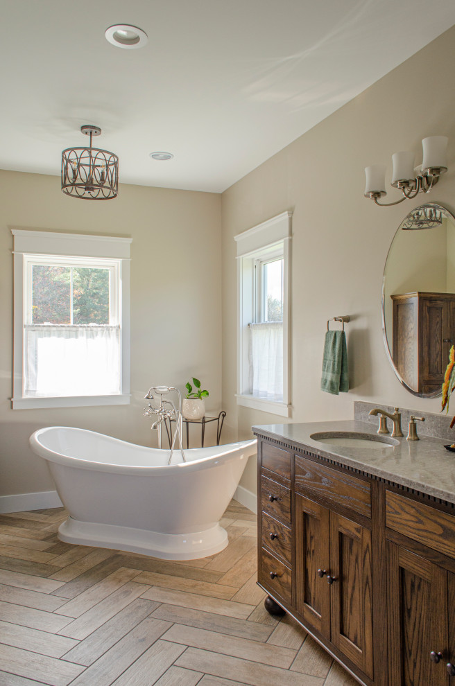 Mid-sized country master bathroom in Columbus with shaker cabinets, dark wood cabinets, a freestanding tub, brown tile, wood-look tile, beige walls, wood-look tile, an undermount sink, engineered quartz benchtops, brown floor, grey benchtops, a double vanity and a built-in vanity.