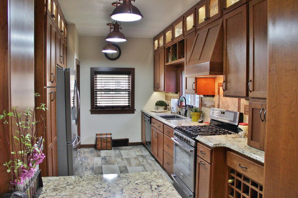 Example of a mid-sized transitional galley ceramic tile enclosed kitchen design with an undermount sink, shaker cabinets, medium tone wood cabinets, quartz countertops, beige backsplash, stone tile backsplash, stainless steel appliances and a peninsula