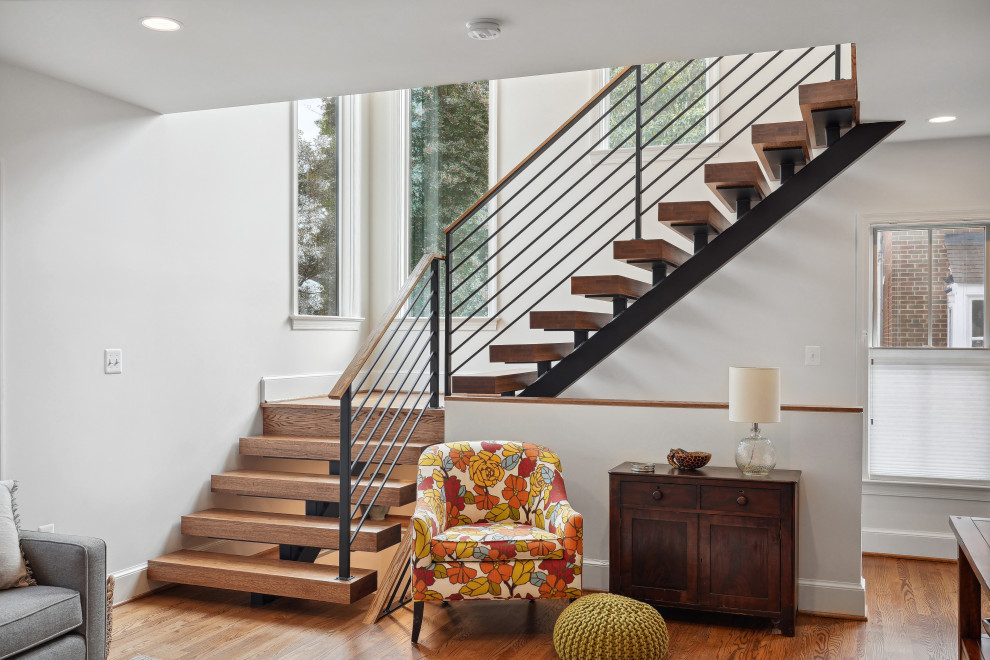 Ejemplo de escalera suspendida tradicional renovada de tamaño medio con escalones de madera, contrahuellas de madera y barandilla de metal