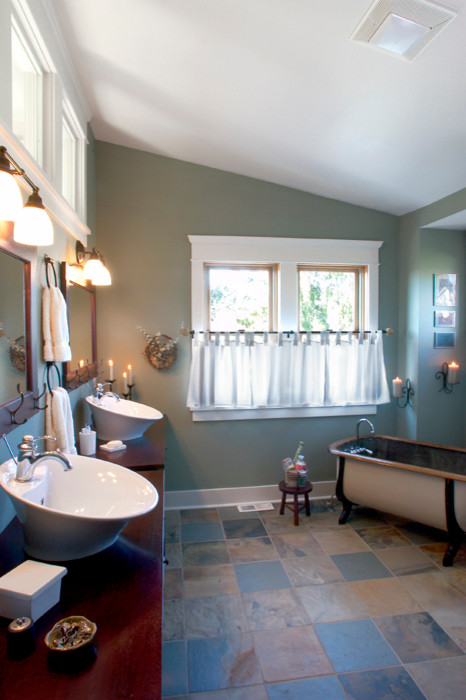 This is an example of an arts and crafts master bathroom in Seattle with a vessel sink, furniture-like cabinets, dark wood cabinets, wood benchtops, a claw-foot tub, an alcove shower, a two-piece toilet, multi-coloured tile, stone tile, green walls and slate floors.