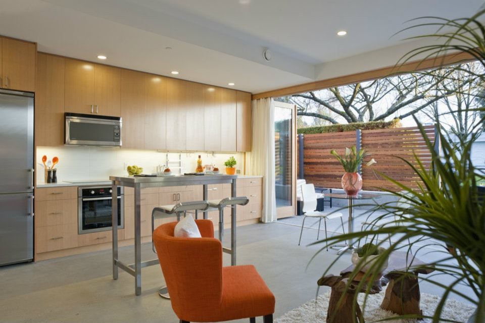 Example of a mid-sized transitional galley porcelain tile kitchen design in Vancouver with flat-panel cabinets, medium tone wood cabinets, marble countertops, ceramic backsplash, stainless steel appliances and an island