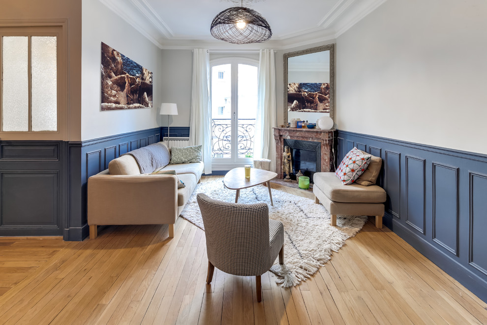 Inspiration for a small transitional open concept living room in Paris with light hardwood floors, a corner fireplace, a stone fireplace surround, grey walls, no tv and beige floor.