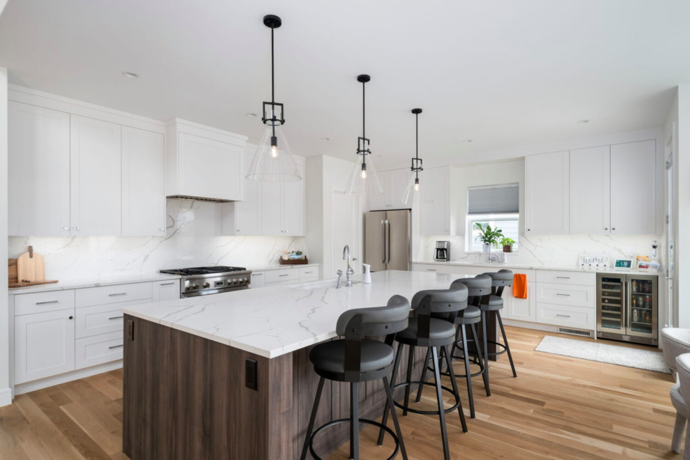Inspiration for a large transitional l-shaped medium tone wood floor, brown floor and coffered ceiling open concept kitchen remodel in Austin with an undermount sink, beaded inset cabinets, white cabinets, quartz countertops, white backsplash, quartz backsplash, stainless steel appliances, an island and white countertops