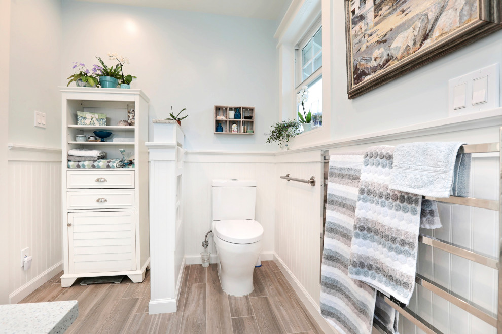 Inspiration for a large beach style master bathroom in San Francisco with shaker cabinets, white cabinets, an undermount tub, a curbless shower, blue tile, porcelain tile, blue walls, porcelain floors, an undermount sink, recycled glass benchtops, brown floor, a hinged shower door and white benchtops.