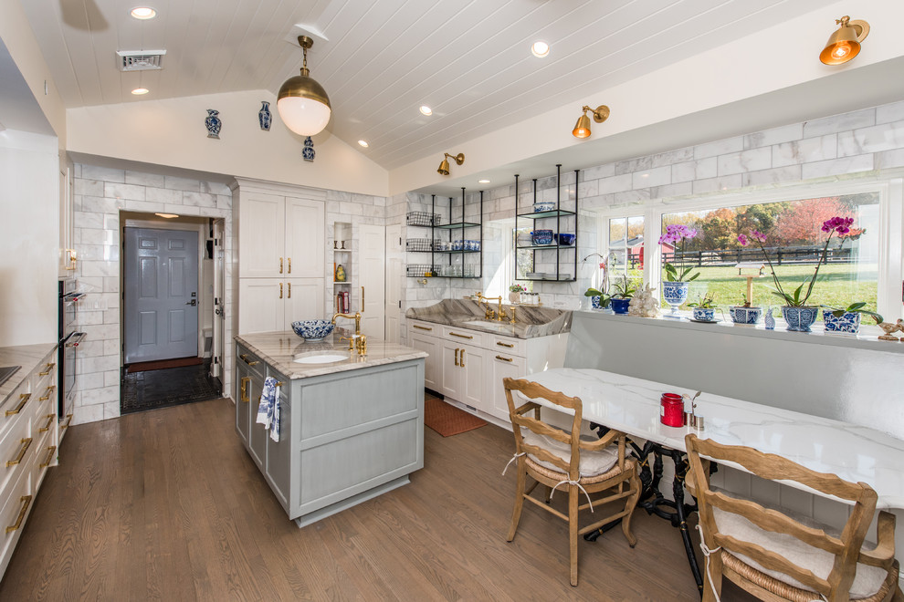 Inspiration for a mid-sized country u-shaped open plan kitchen in DC Metro with an undermount sink, recessed-panel cabinets, yellow cabinets, granite benchtops, grey splashback, stone slab splashback, stainless steel appliances, light hardwood floors and with island.