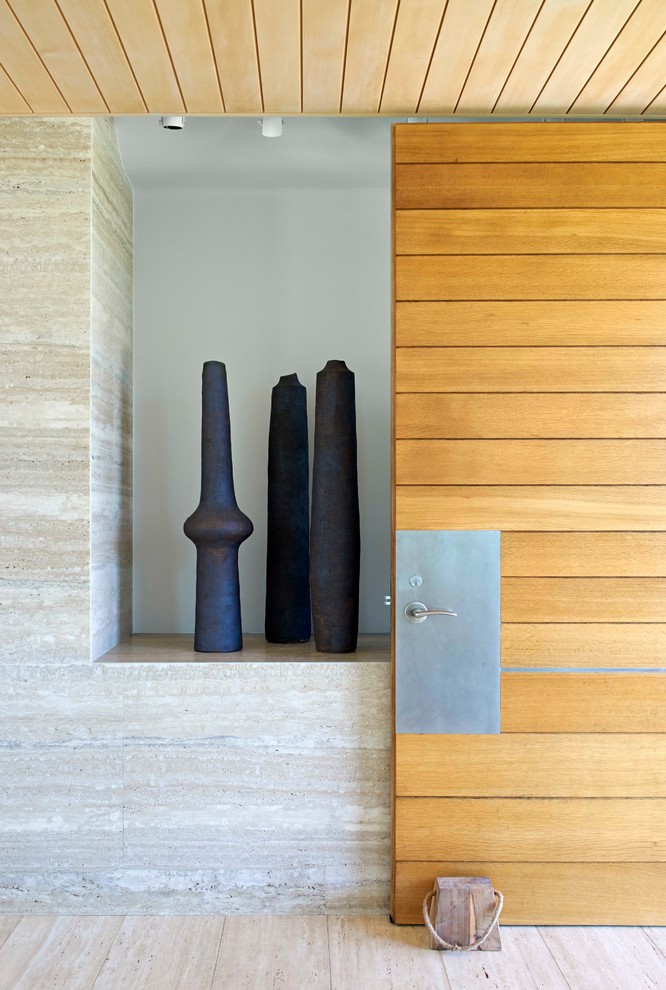 Large contemporary front door in New York with a single front door, a medium wood front door and light hardwood floors.