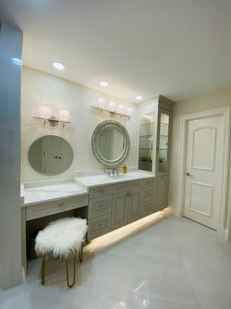 Exemple d'une grande salle de bain principale moderne avec un placard avec porte à panneau encastré, des portes de placard beiges, une baignoire indépendante, une douche double, un bidet, un carrelage gris, du carrelage en marbre, un mur gris, un sol en marbre, un lavabo encastré, un plan de toilette en marbre, aucune cabine, un plan de toilette blanc, une niche, meuble double vasque et meuble-lavabo encastré.