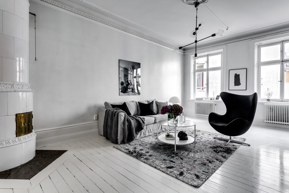 This is an example of a mid-sized traditional formal open concept living room in Stockholm with a corner fireplace, a tile fireplace surround, white walls, painted wood floors and no tv.