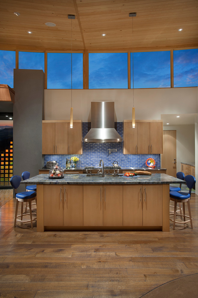 This is an example of a mid-sized contemporary galley eat-in kitchen in Phoenix with an undermount sink, flat-panel cabinets, light wood cabinets, granite benchtops, blue splashback, ceramic splashback, stainless steel appliances, medium hardwood floors, with island and brown floor.