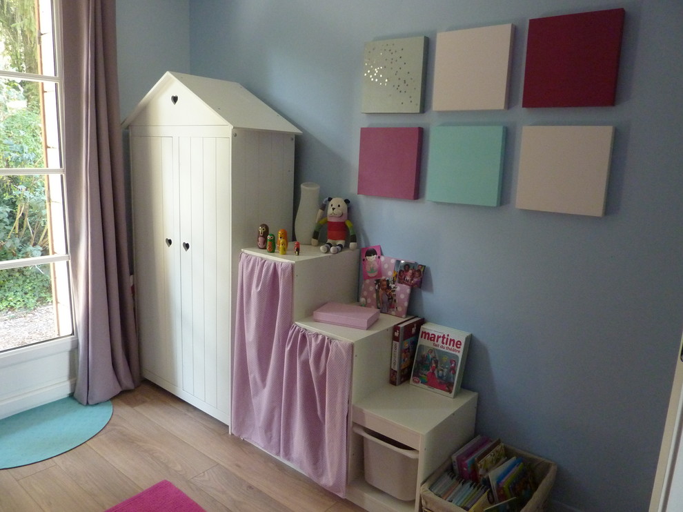 Small contemporary kids' bedroom in Lyon with blue walls and light hardwood floors for kids 4-10 years old and girls.