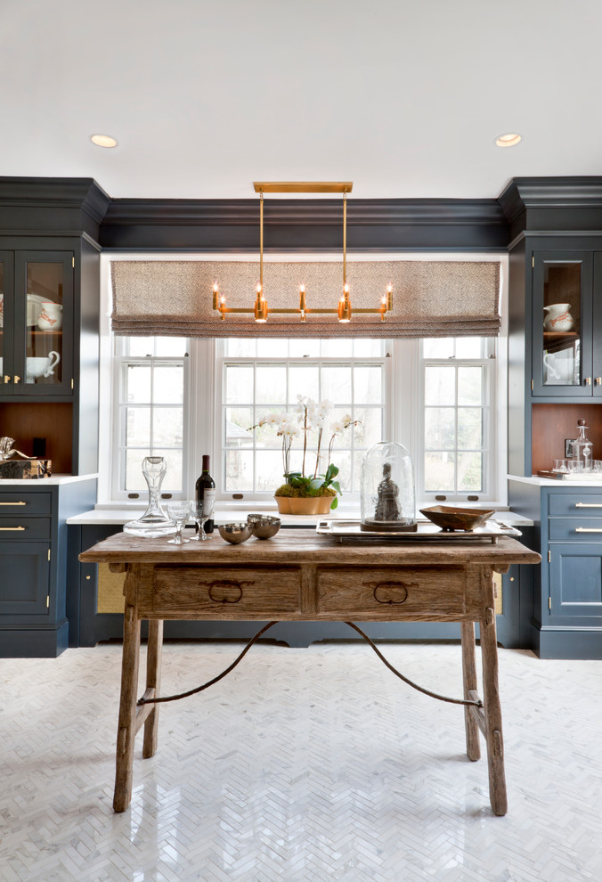 Small traditional galley kitchen in DC Metro with blue cabinets, marble benchtops, panelled appliances and marble floors.