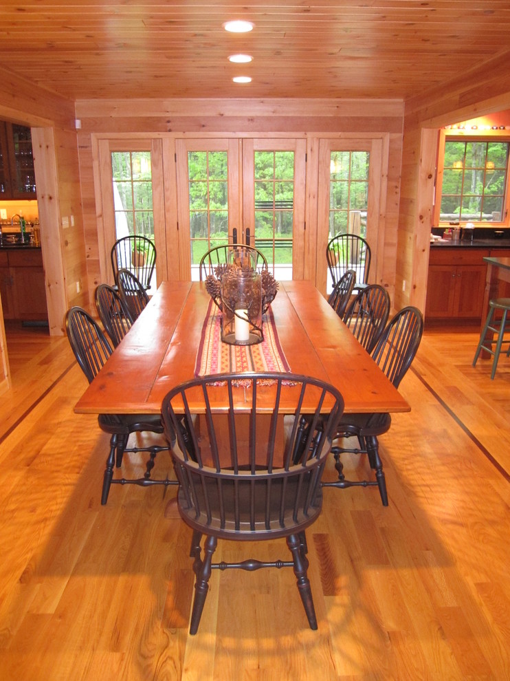 Example of a medium tone wood floor dining room design with brown walls