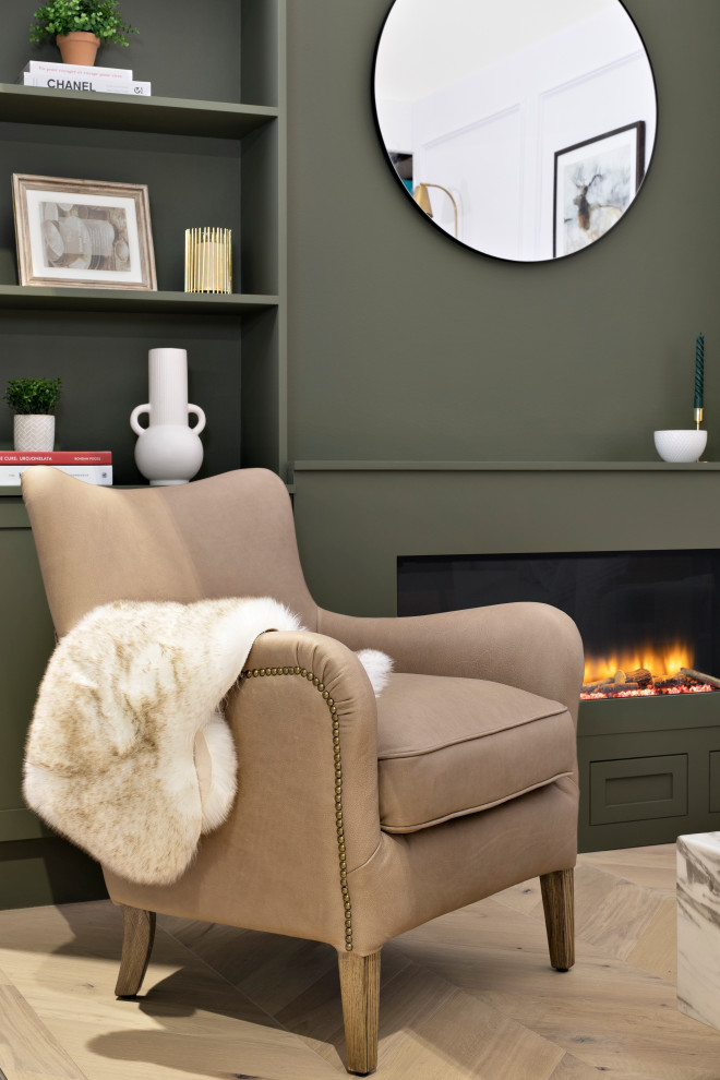 ダブリンにあるお手頃価格の小さなトランジショナルスタイルのおしゃれな独立型リビング (緑の壁、淡色無垢フローリング、標準型暖炉、木材の暖炉まわり、埋込式メディアウォール) の写真