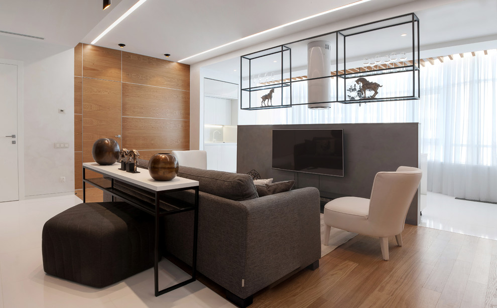 Photo of a contemporary open concept family room in Yekaterinburg with light hardwood floors and a wall-mounted tv.